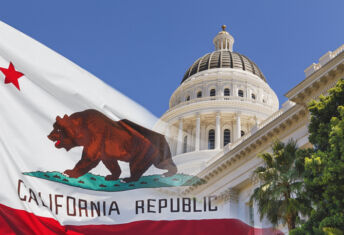Photo of a faded California state flag laid over the California Capitol.