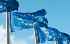 EFRAG tables last-minute reliefs, chooses ISSB alignment on financial effects Row of blue EU flags in Brussels. The blue flags have twelve yellow stars depicting the original number of member states.