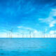 Offshore Wind Turbine in a Windfarm under construction off the England Coast at blue sky