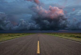 The long road ahead: Engaging with hard-to-abate sectors Desert road with storm clouds